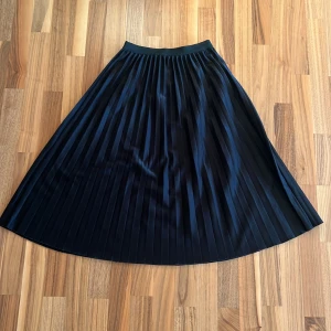 Pliccerad svart kjol - 71 cm lång, töjbar midja