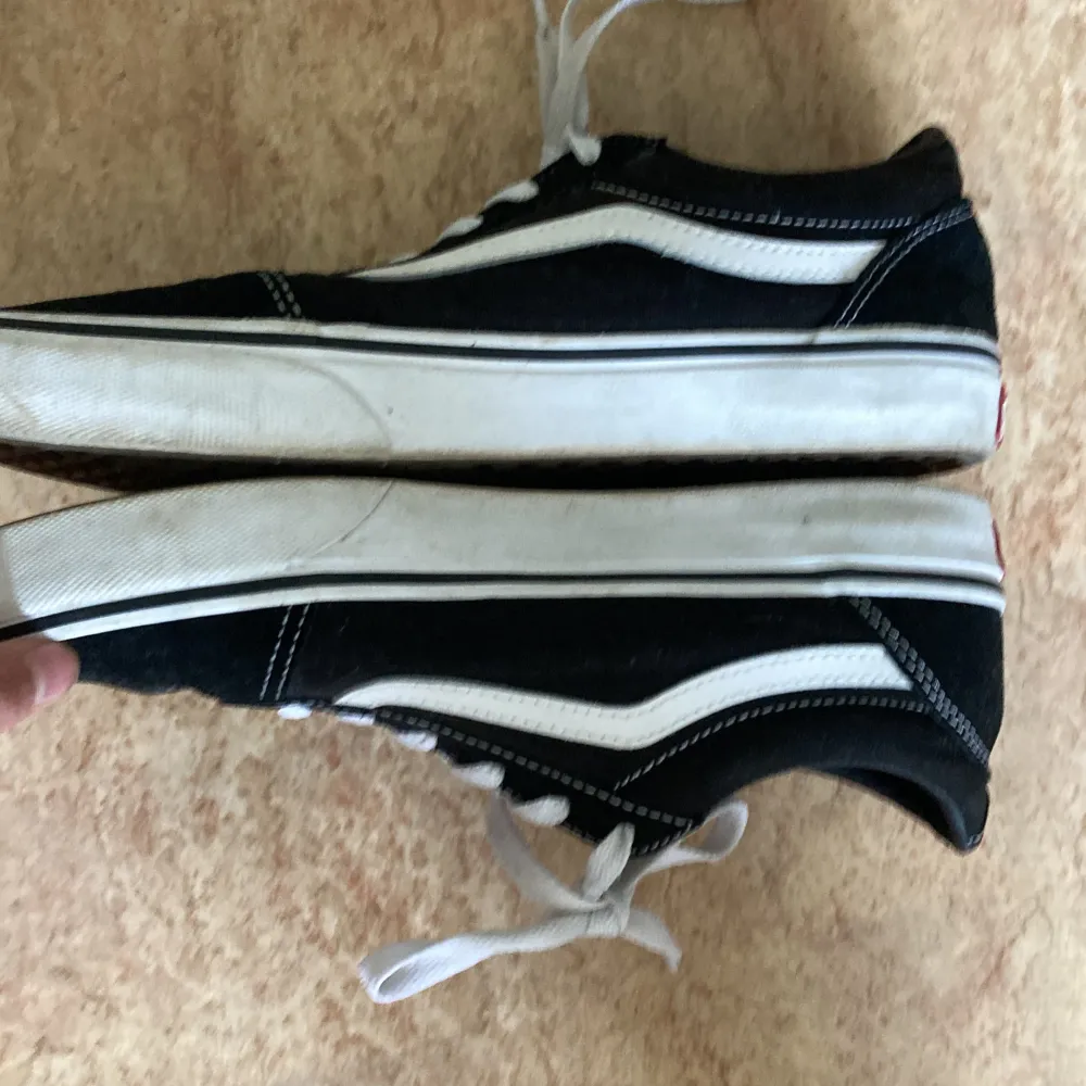 säljer mina gamla vans pågrund av att jag växte ur dom. använd typ 3 gånger.                          ett par svarta Vans sneakers med vita detaljer och snörning. Skorna har en vit sula med det klassiska rutmönstret på undersidan och en röd 'Off the Wall' logotyp på hälen. säljer mina gamla vans pågrund av att jag växte ur dom. använd typ 3 gånger.. Skor.