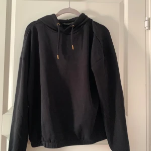 Svart hoddie  -  En svart hoodie från athlecia med guld detaljer. Super bra skick. Ny pris 600kr 