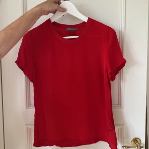 Röd topp - En röd topp i viscos från Calvin Klein, jättefint skick! Materialet är  lite tunnare och än vad det ser ut på bilden