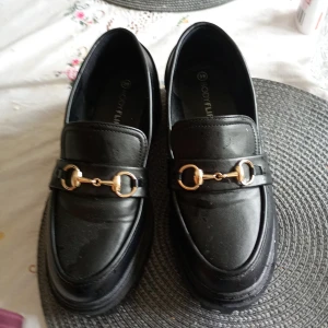 Lofers med spänne guldfärgad stl 39 - Helt nya lofers med guld spänne svarta stl 39.