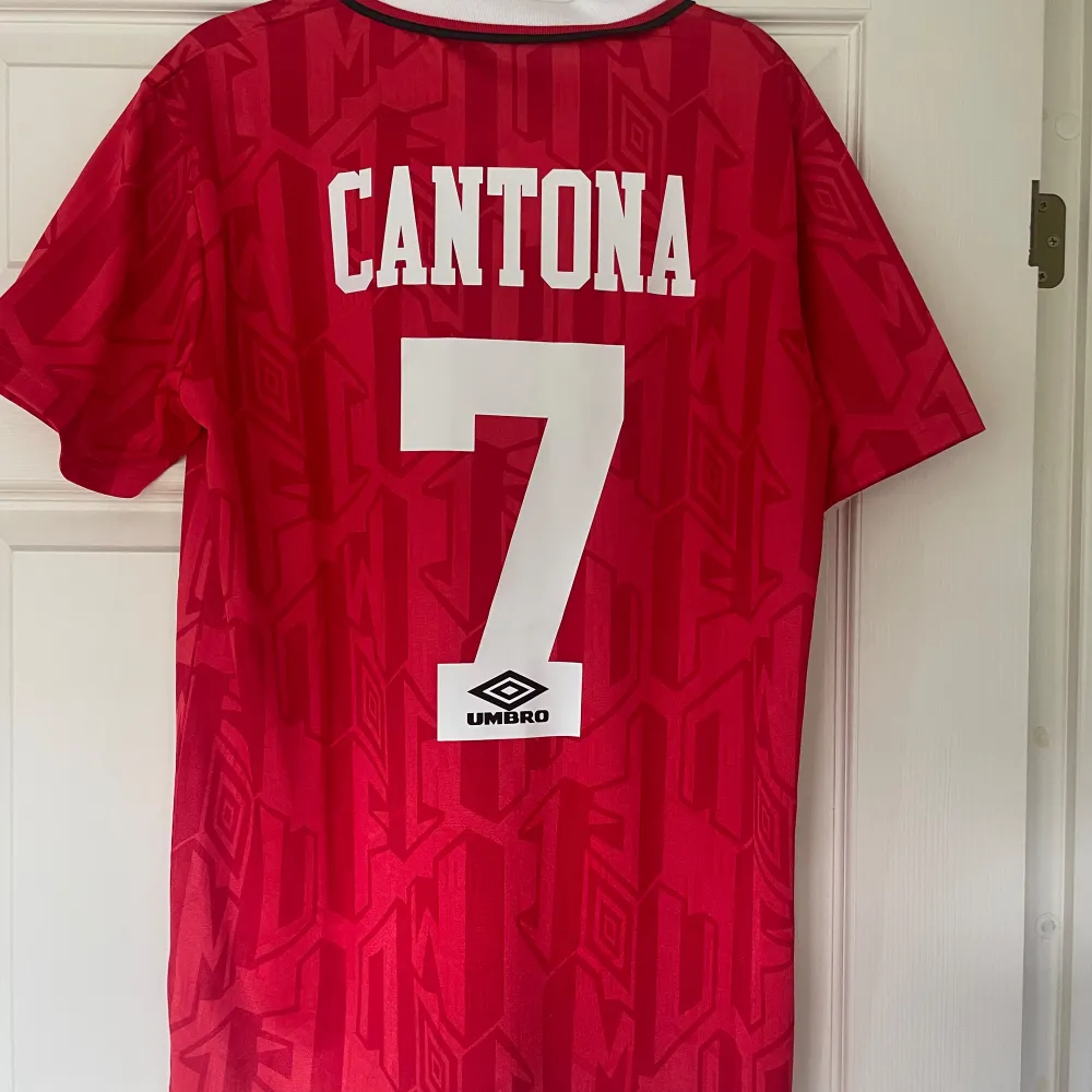 Säljer en Canta re-print fotbollströja från Manchester United. Tröjan är i nyskick och har endast hängt på väggen som dekoration! Storlek: Medium. Sportswear.