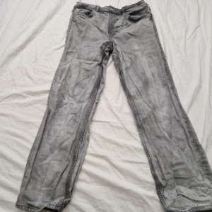 Grå jeansbyxor - Säljer ett par gråa jeans i storlek 38. Byxorna har en straight passform och är tillverkade i bomull. knappast andvända då de är för små, köpta för 200kr, säljer för 100kr.
