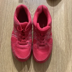 Rosa sneakers med vit sula - Säljer ett par snygga rosa sneakers med vit sula. De har en sportig design med meshmaterial för bra andningsförmåga och snörning framtill. Perfekta för träning eller vardagsbruk. De är i bra skick och redo för en ny ägare!