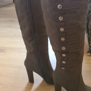 Höga stövlar  - Endast använda en gång inomhus men finns några märken under sulan som syns på bilden. 