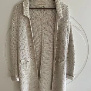 Beige stickad kappa från Odd Molly - Säljer en superfin beige stickad kappa från Odd Molly. Den är i storlek M och har en mysig och varm känsla. Perfekt för höst och vår! Den har långa ärmar och fina detaljer som knappar och en broderad text på ryggen. Passar både till vardags och lite finare tillfällen.