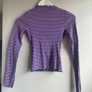 Randig långärmad tröja - Supersnygg och skön långärmad tröja med rosa och blå ränder samt rullfållad kant! Så fin till jeans💓 Knappt använd!