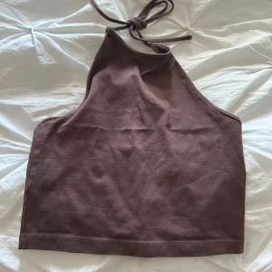 Brun halterneck topp från Bik Bok - En brun halterneck topp från Bik Bok. Toppen är ärmlös och har en knytning i nacken.