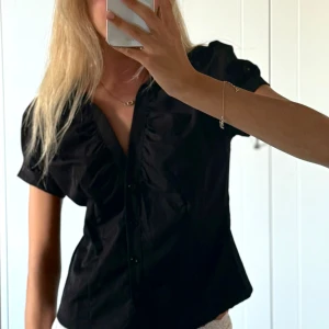 Kortärmad skjorta  - Säljer denna svarta kortärmade skjorta från Shein då den är för stor för mig. Tror den ska ha en figurnära passform. Aldrig använd, bara testad.