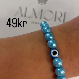 Blått armband från Almori - Ett blått armband med pärlor och ett öga-design från Almori.