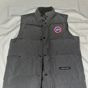 Canada Goose väst  - Jag säljer min Canada Goose väst, storleken är M och färgen är grå den är knappt använd och är helt ny utan nån skada.