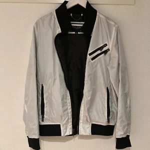 Cool vind/regn jacka Guess - Inköpt på Guess i New York. Iprincip oanvänd. Kanske en kväll vid köp;) En normal herr medium. Blankvit med rustika svarta dragkedjor & muddar