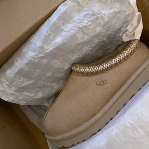 UGG tasman - Säljer mina Ugg tasman då jag ej får användning av dem. Köpta på merch Sweden för 3000kr. Då jag fortfarande tycker om dem och dem är sååå fina så säljer jag till högst budande. Storlek 36, impregnerade, endast använda inomhus ett fåtal tillfällen✨ 