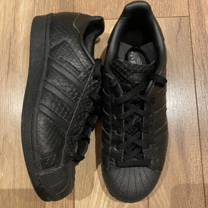 Adidas superstar black snakeskin - Svarta skor från adidas, modell superstar med snakeskin. Storlek 38, använda fåtal gånger