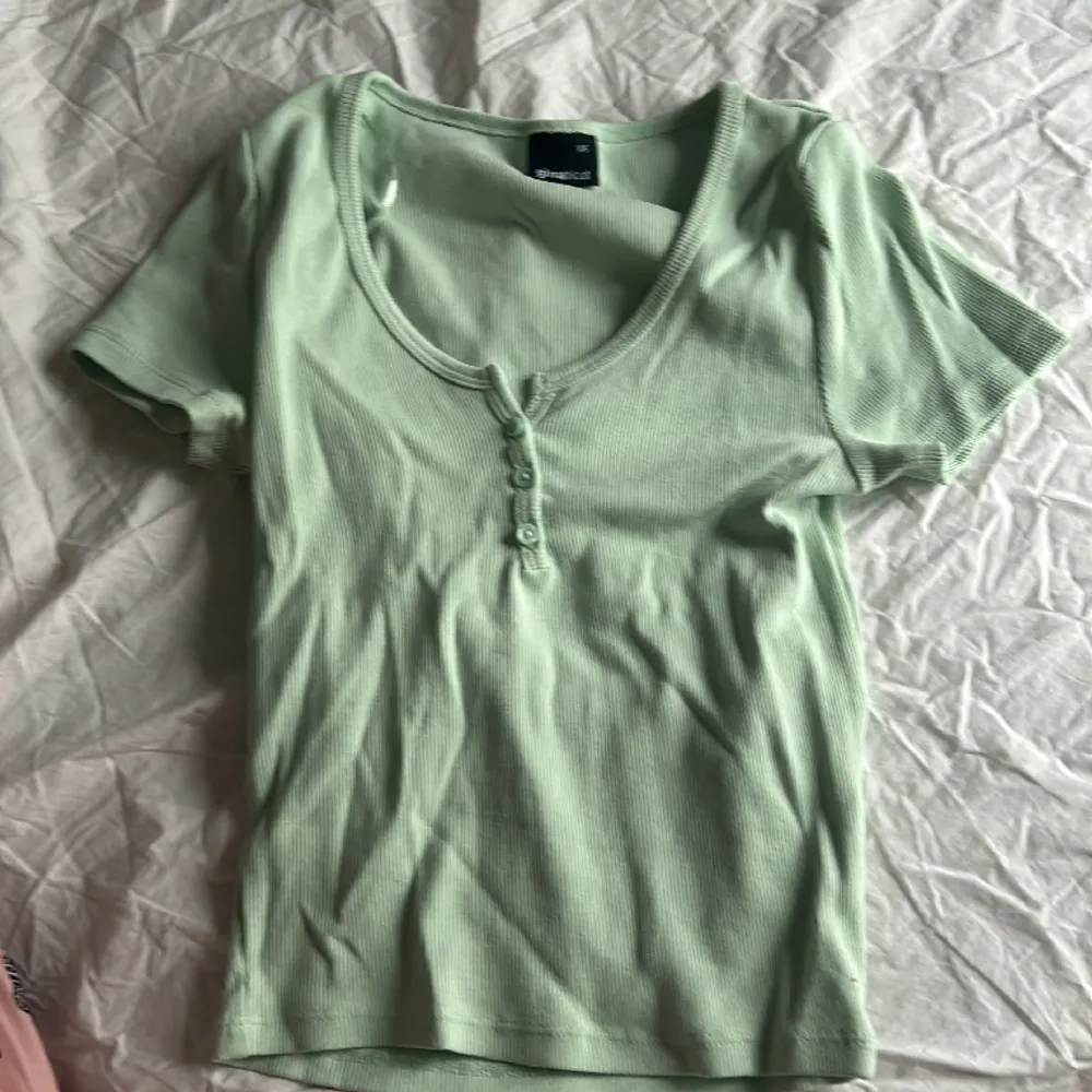 En grön topp med kort armar och lite urringad från Gina tricot. T-shirts.