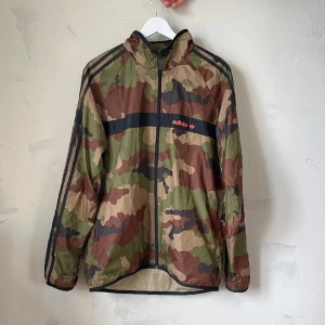 Adidas camo vindjacka - Väldigt sparsamt använd adidasjacka, kanske max 4-5 ggr. Inga defekter alls. Det finns en huva i kragen som man kan ta ut också. Köparen betalar frakten, annars finns den att hämta i södra sthlm! 😊 Kolla gärna mina andra annonser!