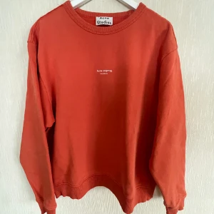 Acne-collagetröja - Röd/orange collage-tröja från Acne Studios. Nypris cirka 2000. Använd men i bra skick.