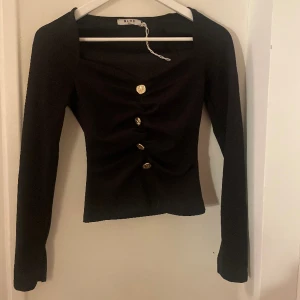 Långärmad topp - Långärmad tröja med guldknappar i storlek XS