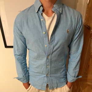 Ralph Lauren Skjorta - Snygg skjorta från Ralph Lauren. Det finns en liten defekt på framsidan(se bild 2). Sitter bra på modellen som är 174.