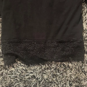 Svart top😍😍 - Svart topp med en kort krage och spets på botten.🖤✨