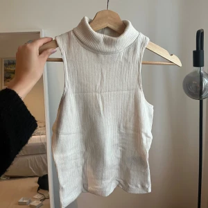 Linne med hög hals - Ribbat linne med hög hals som går att vika ner, bra skick