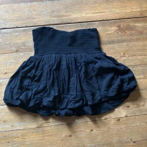 Svart kjol från Lindex - En svart kjol från Lindex med en elastisk midja och en voluminös, rynkad nederdel. Kjolen är kort och har en bekväm passform. Finfinkvalite 8/10. Skicka dm vid frågor!