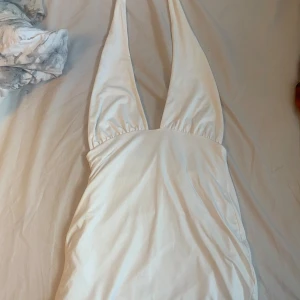 Vit klänning med urigning och snören runt halsen  - Fin enkel klänning, kan användas till finare tillställningar som födelsedagsfest, eller andra typer av fester. 