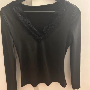 Svart spets topp - Säljer denna svarta långarmade tröja med spets detaljer, tyvärr vet ja inte storleken men skulle säga runt xs/s, har inga fler bilder då den var förliten för mig. 