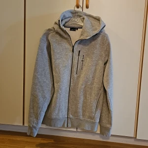 Grå Sail Racing hoodie - Köpt här på plick men den var tyvärr för stor. Jätte fint skick!