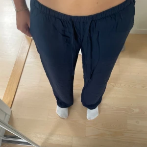 Mörkblå lågmidjade linnebyxor - Jättefina lågmidjade linnebyxor från ginatricot. Byxorna är i färgen mörkblå. Storlek XS. Fint skick!Byxorna är uppsydda men längden är enligt andra bilden på mig som är ungefär 160 cm. Skriv för fler bilder eller andra funderingar!💙