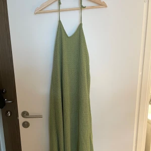 Halterneck klänning - Säljer nu denna klänning från Pull&Bear. Jag har sytt om den lite så att det är en justerbar halterneck. Klänningen har ett litet hål i ena sidan, men det är inget som syns särskilt mycket. Den går nästan ner till fötterna på mig som är 163cm lång.