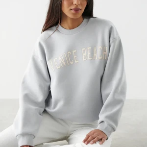 Oversize printed sweater - Ginatricot  - Collegetröja med tryck framtill. Collegetröjan är blå och har oversize fit. Den har en rund halsringning och en ribbmudd vid ärmsluten och på nederfållen. Slutsåld överallt, original pris 399kr. Säljer för 99kr