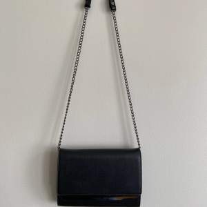 Säljer en svart handväska! Väskan är i gott skick förutom att ena knappen på bandet har lossnat (se bild). Väskan är 20,5cm bred och 14,5cm hög✨