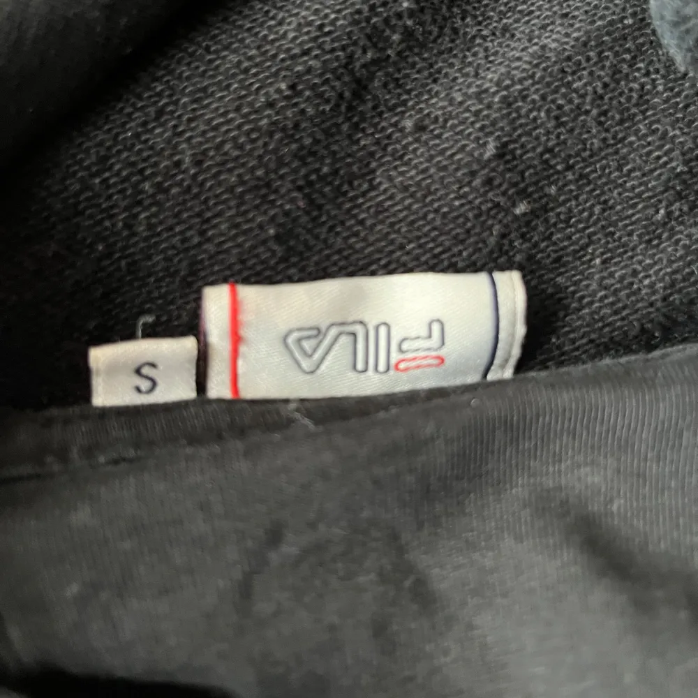 En svart fila tröja i storlek S,har ett mindre  fila märke längst ner på ryggen på sidan typ och sen ett större fila märke fram . Hoodies.