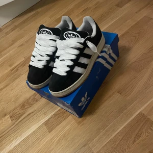 Adidas Campus 00s - Skor till salu igen!! Jag vill sälja dessa på grund av att de har blivit för små för mig men de är dock jättesnygga och trendiga. De är sparsamt använda i cirka 1 månad. Svarta snören ingår! Hör av er vid frågor och priset går att diskuteras🙌🙌🔥