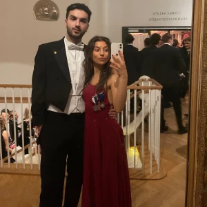 Balklänning  - Supervacker röd balklänning med öppen rygg och en slit på ena benet. Den har använts en gång och vill nu ha ett nytt hem!