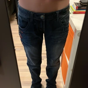 Jeans med tryck! - Vintage desingual, liknande Ed Hardy jeans! Köpta second hand men har tyvärr inte kommit till så mycket användning då de är lite långa för mig som är 163. Dock så fungerar det även superbra att vika upp de! Mid eller low waist. Skriv för frågor!  💞