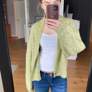 Stickad kofta  - En stickad kofta som är flerfärgad och väldigt mysig. Den har snygga detaljer med knappar längst ned. Den sitter snyggt lite oversized på mig som är 167. Den är köpt second hand men märket är monki och storlek L. 