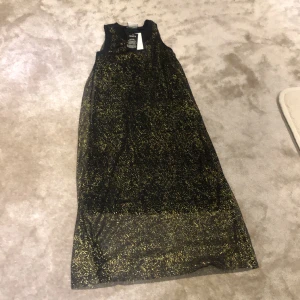 Guldglittrande klänning  - Helt oanvänd svart festklänning som glittrar i guld 