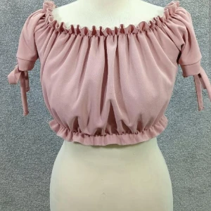 Off shoulder top - Färgen motsvarar första bilden (dusty pink/gammelrosa). Band vid midjan och runt axlarna vid ruschet så den sitter på plats. Snörning till rosett vid armarna. Från New Look i stl 34. Enstaka ställen vid ruschet har töjts ut men inget som syns.