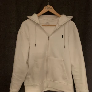 Polo Ralph Lauren luvtröja  - Vit polo Ralph Lauren luvtröja i storlek S. Snart 1 år gammal. Har tagit väldigt bra hand om den, den är som i nyskick. Säljer pga att jag nästan aldrig använder den längre.   Jag är 183cm, 65kg  Nypris: 1499 Pris kan diskuteras :)