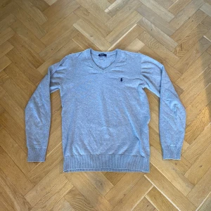 Ralph Lauren Knitted V-neck - Denna riktigt stiliga gråa ralph lauren koftan är i väldigt bra skick och riktigt snygg fär sommaren!
