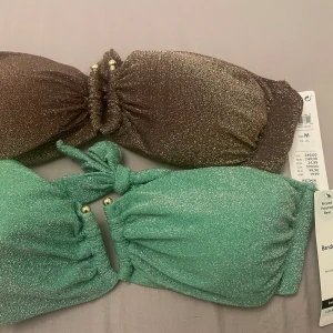 Glitter bandeau överdel bikini  - Superfina glitter bikini överdelar från Lindex, båda färgerna är  i storlek M och säljer båda för 350 eller 1 för 200. Ordinarie pris är 249kr/st.  Inte använda, prislapp finns kvar.  Säljer för att jag tappat bort kvittot och inte kunnat returnera. 