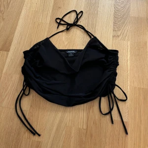 Crop top i mesh - Svart crop trop i mesh med snörning vid sidorna samt runt nacken.🖤 Snörningen vid sidan gör att man kan justera passformen på toppen 