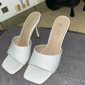 Slip in heels - Vita slip in klackar. Väldigt fina, passar till mycket och så gott som nya. Storlek 37 o har en ca 8 cm klack. Använda 1 gång. Priset går att diskuteras 