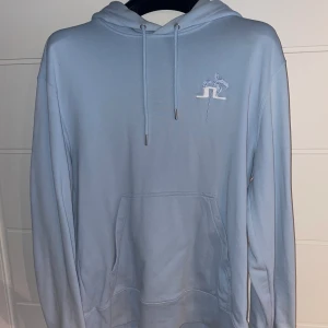 Ljusblå Hoodie J.linderberg - Ljusblå Hoodie från J.linderberg. Använd fåtalet gånger, är i  mycket bra skick. Storlek M 