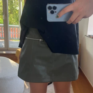 Skinn shorts  - Mörkgröna skinn shorts som ser ut som en kjol framtill 