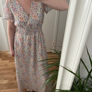 Maxiklänning - Blommig maxiklänning från NA-KD, helt oanvänd! Väldigt stretchig så passar även S!