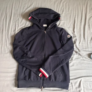 Moncler Hoodie  - Hej! Säljer nu min Moncler Maglia Cardigan då jag växt ur den. Välanvänd och snörerna saknas annars perfekt! 🤩 NFC scannen vid patchen fungerar samt qr koden vid industry tagsen. Tveka inte att skicka ett pm ifall du har någon fråga eller liknande. 😊