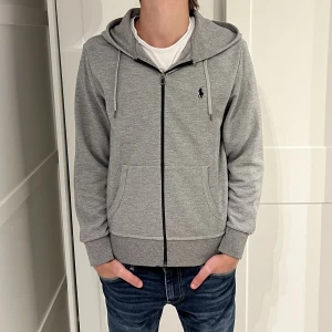 Ralph Lauren Hoodie - Grå Ralph Lauren Hoodie. Tröjan är lite nopprig (se bild) dock inget som man läger märke till när den är på. Modellen är 176cm och väger 65kg. Size S. Hör av dig vid funderingar! (Nypris 1600)